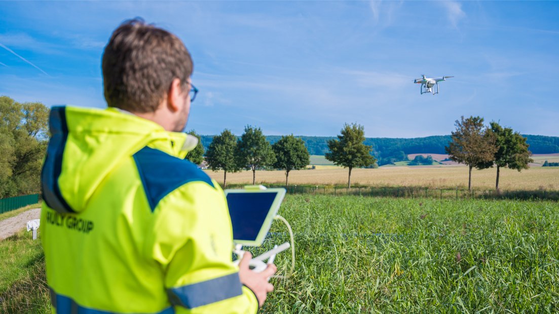 Person steuert, Drohne über Schilfbeet