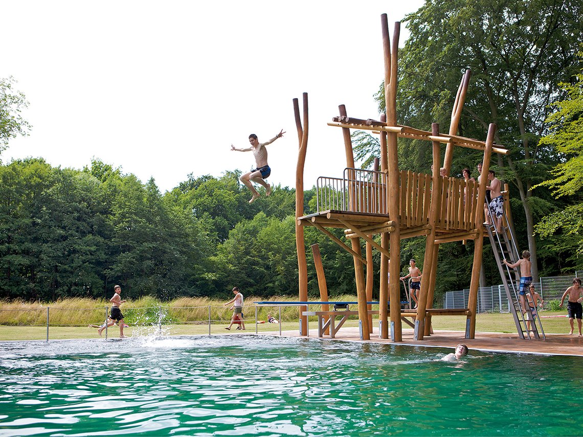 Kletter Sprungturm aus holz in einem Freibad am Wasser