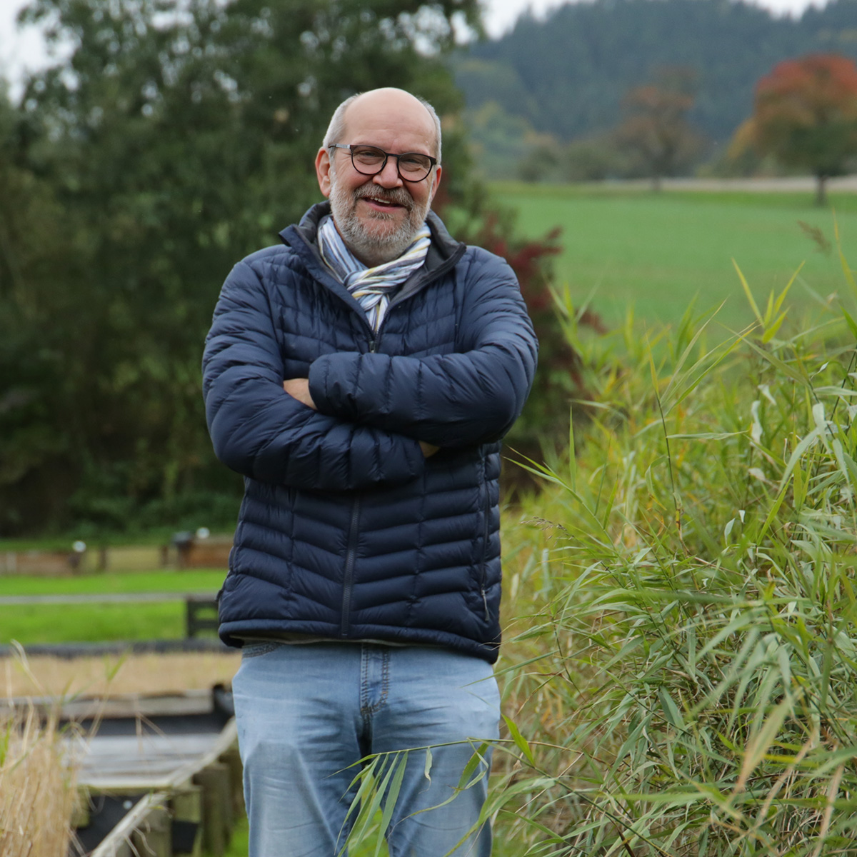 Mann: Udo Pauly steht lächeln an einem Schilfbeet
