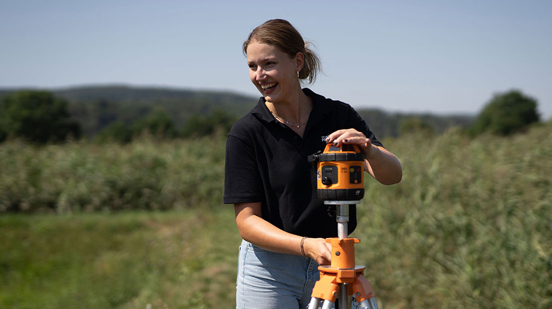 Mitarbeiterin mit Werkzeug auf Klärschilfanlage