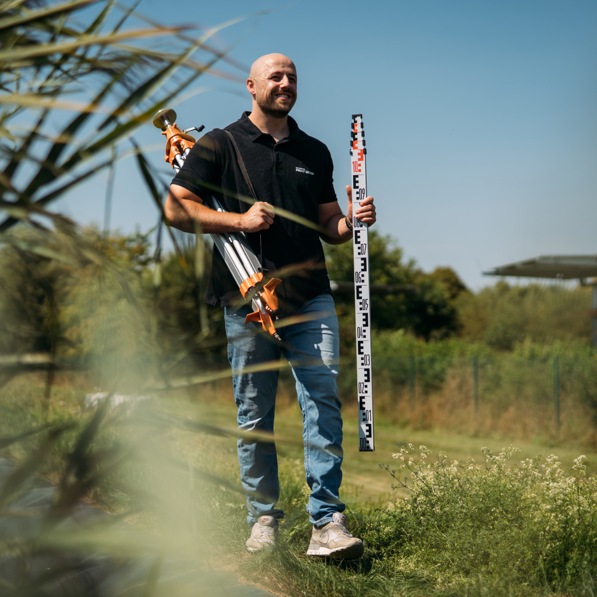 Mitarbeiter auf einem Schilfbeet mit Werkzeugen in beiden Händen